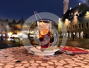 glass of fruite tea with lemon on table at night street caffee in Tallinn old town