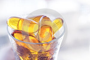 Glass full of Cod liver oil capsules