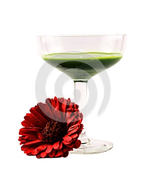 Glass full with green cocktail and a red flower on a white background