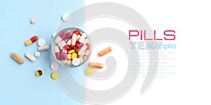 A glass full of pills, tablets, capsules on blue and white background, with empty space for text. Top view