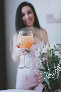 glass glass with orange juice in the hands of a brunette girl close-up