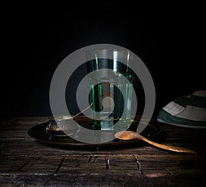 Glass glass with water on a wooden table. Dark background