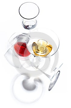 Glass glasses with drinks of different colors on a white background. Top view. The concept of an alcoholic cocktail