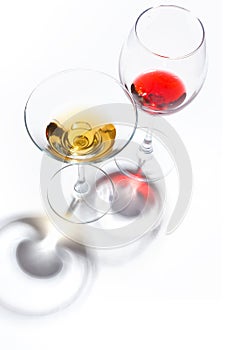 Glass glasses with drinks of different colors on a white background. Top view. The concept of an alcoholic cocktail