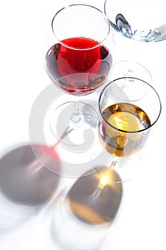 Glass glasses with drinks of different colors on a white background. Top view. The concept of an alcoholic cocktail