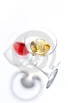 Glass glasses with drinks of different colors on a white background. Top view. The concept of an alcoholic cocktail