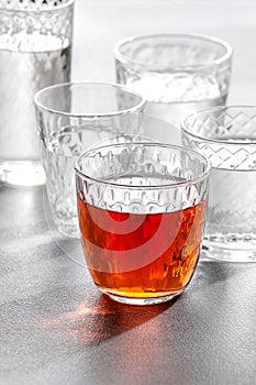 Glass glasses with water and drinks on a gray stone background