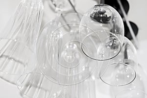 Glass glasses for wine and champagne hang in a bar in a row.