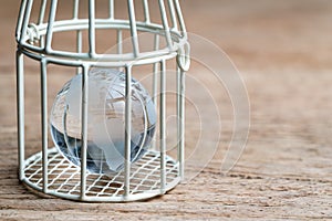 Glass globe with america map inside birdcage on wooden table met