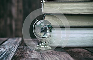 Glass globe on the background of the books