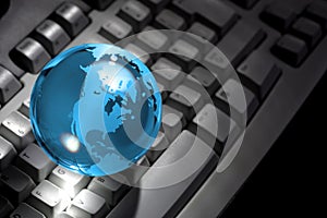 Glass globe on computer keyboard