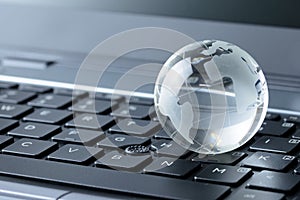Glass globe on laptop keyboard