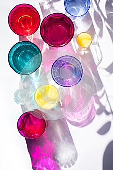 Glass goblets create wonderful coloured shadows on a solar table. The shadow of sunlight reflect to glass of pink and