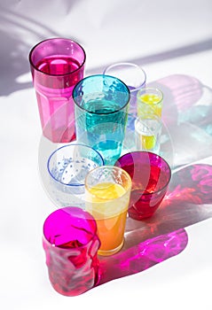 Glass goblets create wonderful coloured shadows on a solar table. The shadow of sunlight reflect to glass of pink and