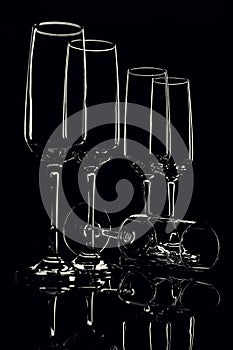 Glass goblets outlined with light on a black background