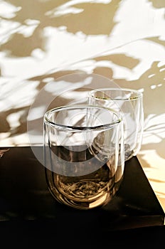 Glass goblets on a wall background with shadows