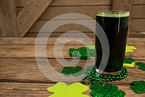 Glass of green beer, beads and shamrock for St Patricks Day