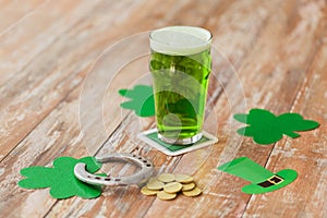 Glass of green beer, horseshoe and gold coins
