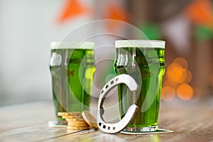 Glass of green beer, horseshoe and gold coins