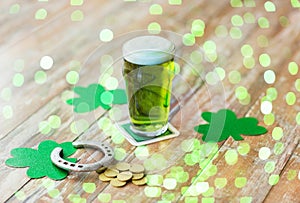 Glass of green beer, horseshoe and gold coins