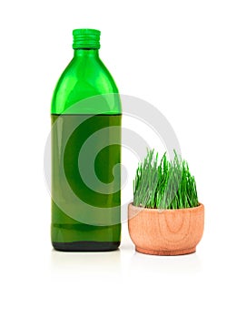 Glass green bottle and sprouts of wheat in wooden bowl isolated