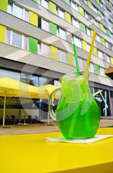 Glass of green estragon lemonade on outdoor table
