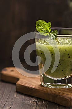 Glass of green refreshing smoothie with kiwi, cucumber and apple