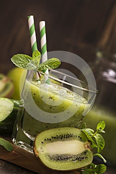 Glass of green refreshing smoothie with kiwi, cucumber and apple