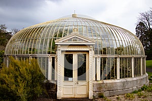 Glass greenhouse in summer. Old vintage glasshouse from the seventies still in use. Backyard vegetable garden