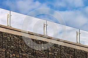 Glass handrails on a roof against cloudy sky background photo