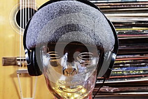 Glass head with headphones and vintage record albums