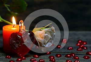 Glass heart, rose flower and burning candle