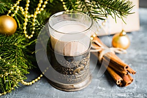 Glass of hot chocolate in winter decorations on the rustic background