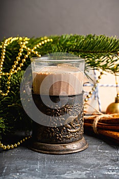 Glass of hot chocolate in winter decorations on the rustic background
