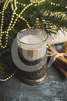 Glass of hot chocolate in winter decorations on the rustic background