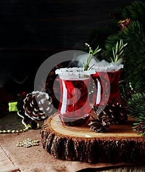 Glass of hot mulled wine for the new year with ingredients for cooking, nuts and Christmas decorations