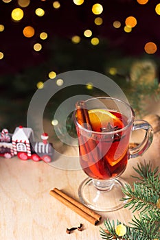 Glass of Hot Mulled wine. Winter homemade drink. Concept of Christmas festive atmosphere, cozy mood. Fir trees lights