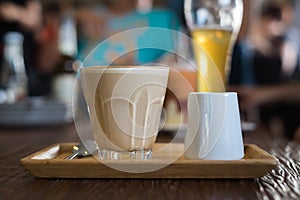 A glass of hot Piccolo latte coffee on wood tray