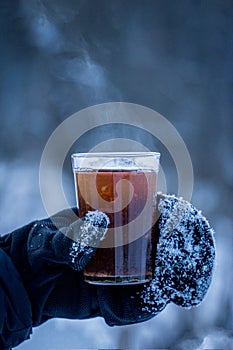 A glass of hot tea in the cold