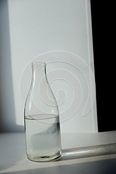 A glass with ice and a bottle of water