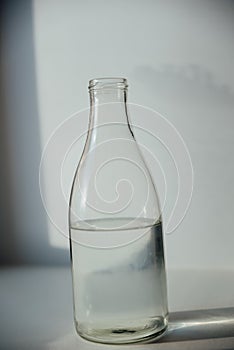 A glass with ice and a bottle of water