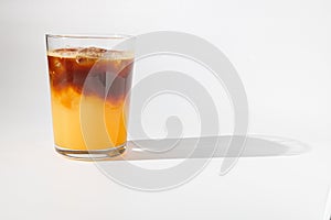 Glass of ice coffee with cream poured over, ice cubes