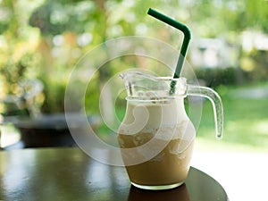 Glass of ice coffee frappe drink on wood table in sunshine morning. Coffee time for relax