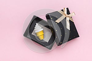 A glass of ice cream in a black gift box on a pink background