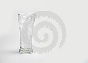 Glass with ice cubes on white background