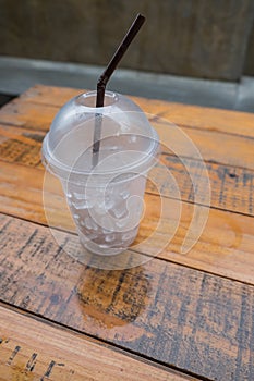 A glass of ice cubes on wooden