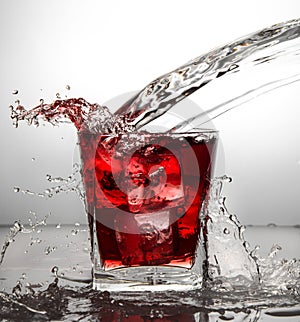 Glass with ice and liquid splash