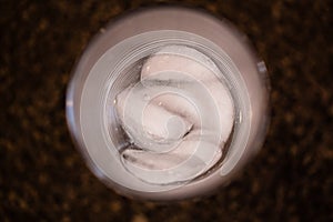 Glass of ice melting, top view photo