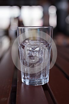 A glass of ice with water drop condense around it.