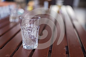 A glass of ice with water drop condense around it.